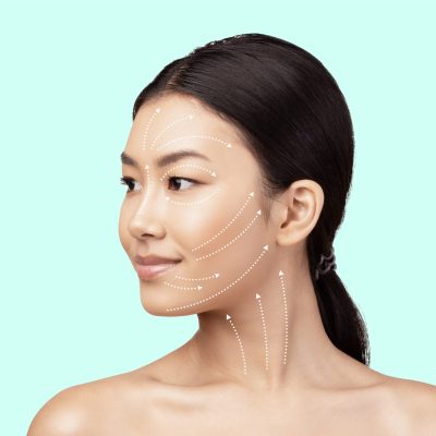 Asian Woman's Face Portrait With Lifting Arrows Showing Antiaging Facial Skincare Treatment, Headshot On White Studio Background, Looking Aside. Ageless Beauty And Plastic Surgery Concept